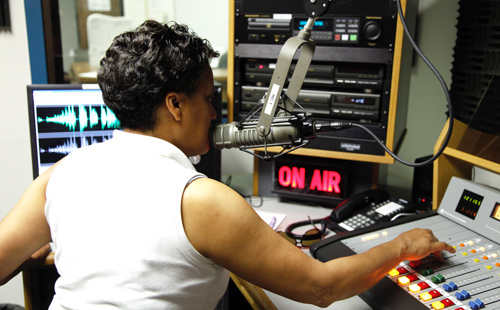 woman working sound board in the MC radio station