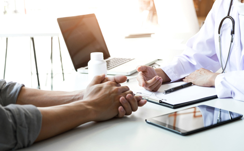 image of physician and patient hands across desk