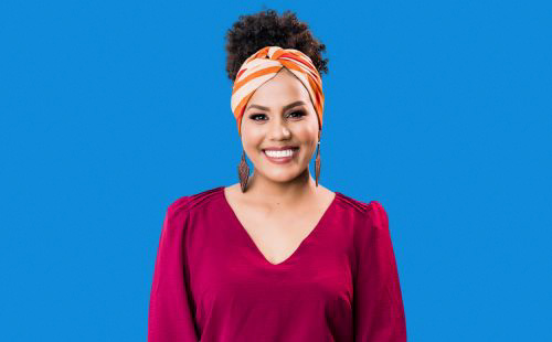 a woman smiling with a blue background.
